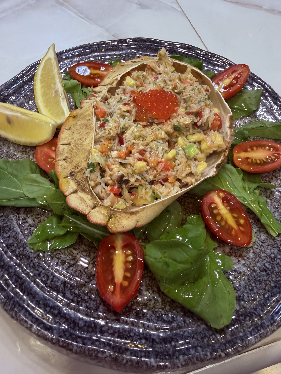 Crab salad served in the shell with roe and fresh greens